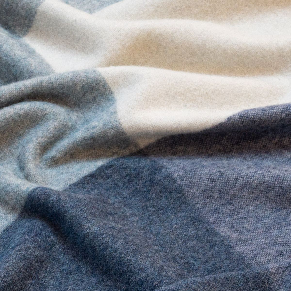 Close-up of the ALPAKA Classic Check throw showing its woven check pattern