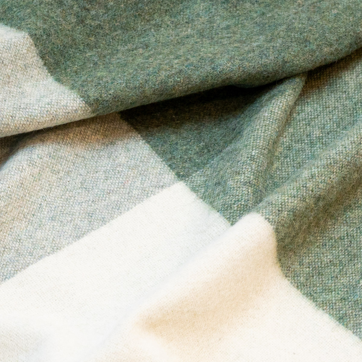 Close-up of the Green ALPAKA Classic Check throw showing its woven check pattern