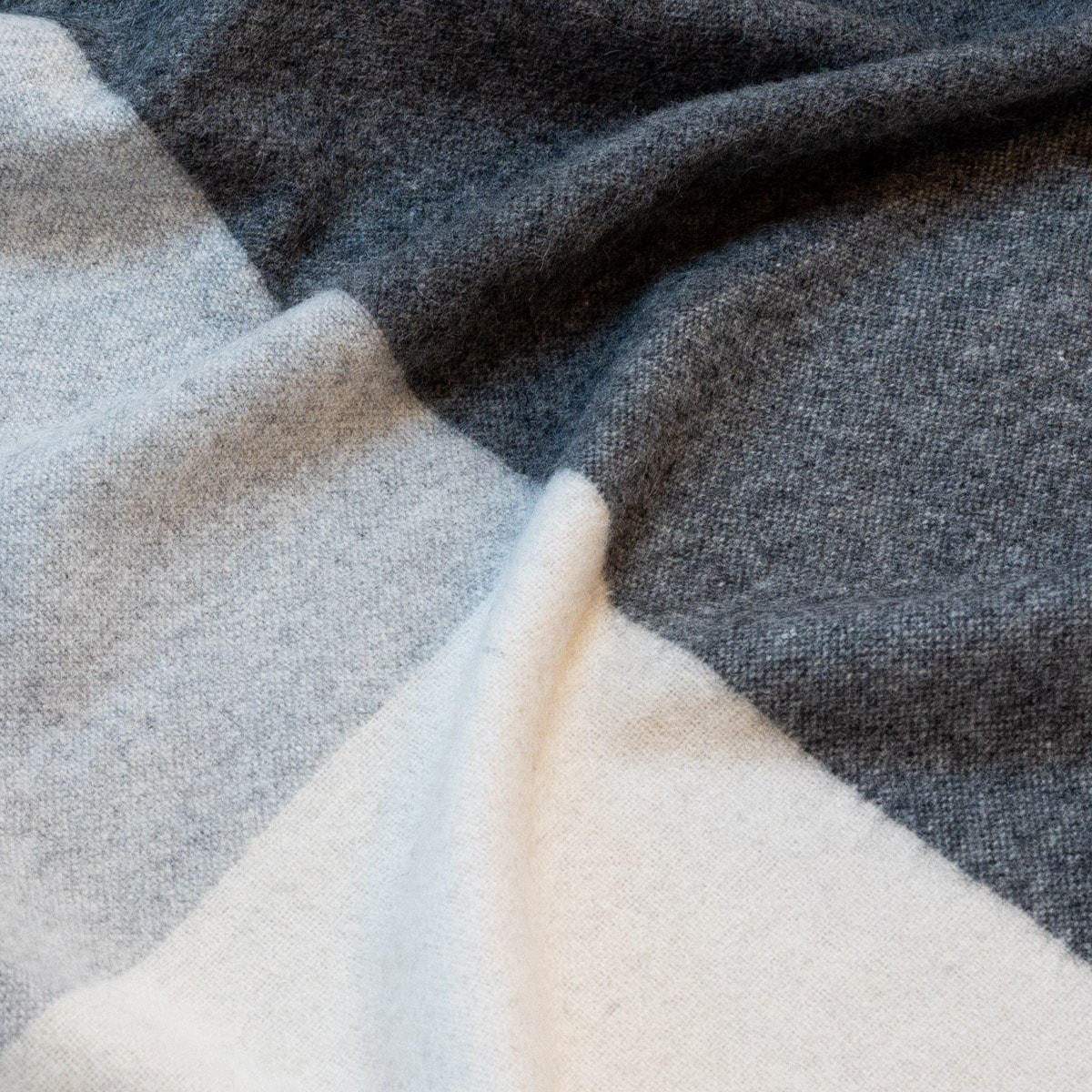 Close-up of the ALPAKA Classic Check throw showing its woven check pattern